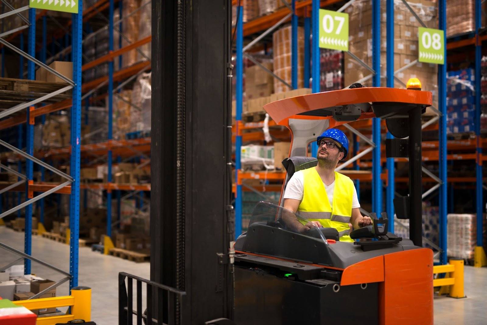 Warehouse worker operating a modern forklift inside a logistics facility, showcasing equipment provided by professional Forklift Suppliers in Dubai.